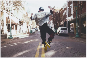 person jumping on city street 